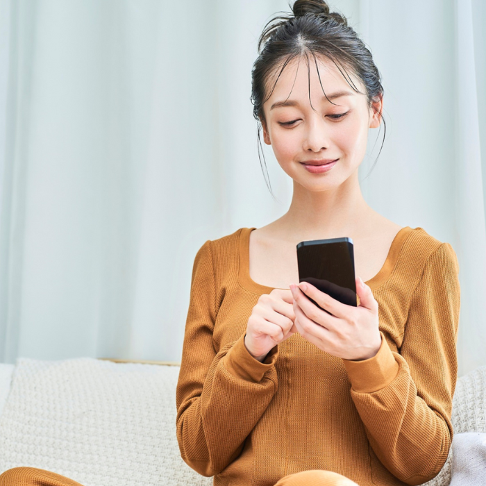 スマホを片手に持って何やら言葉を打っている女性