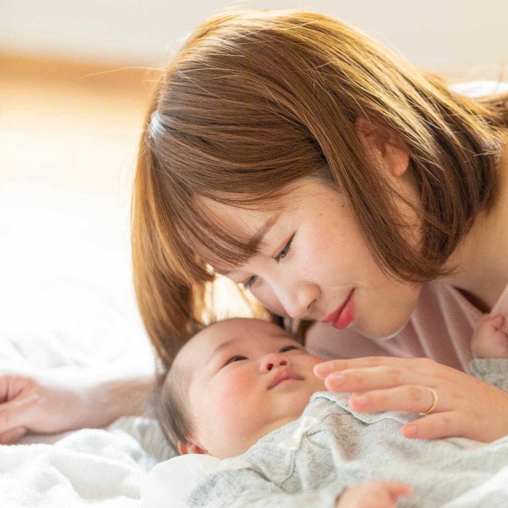 赤ちゃんをいとおしそうに見つめるママ